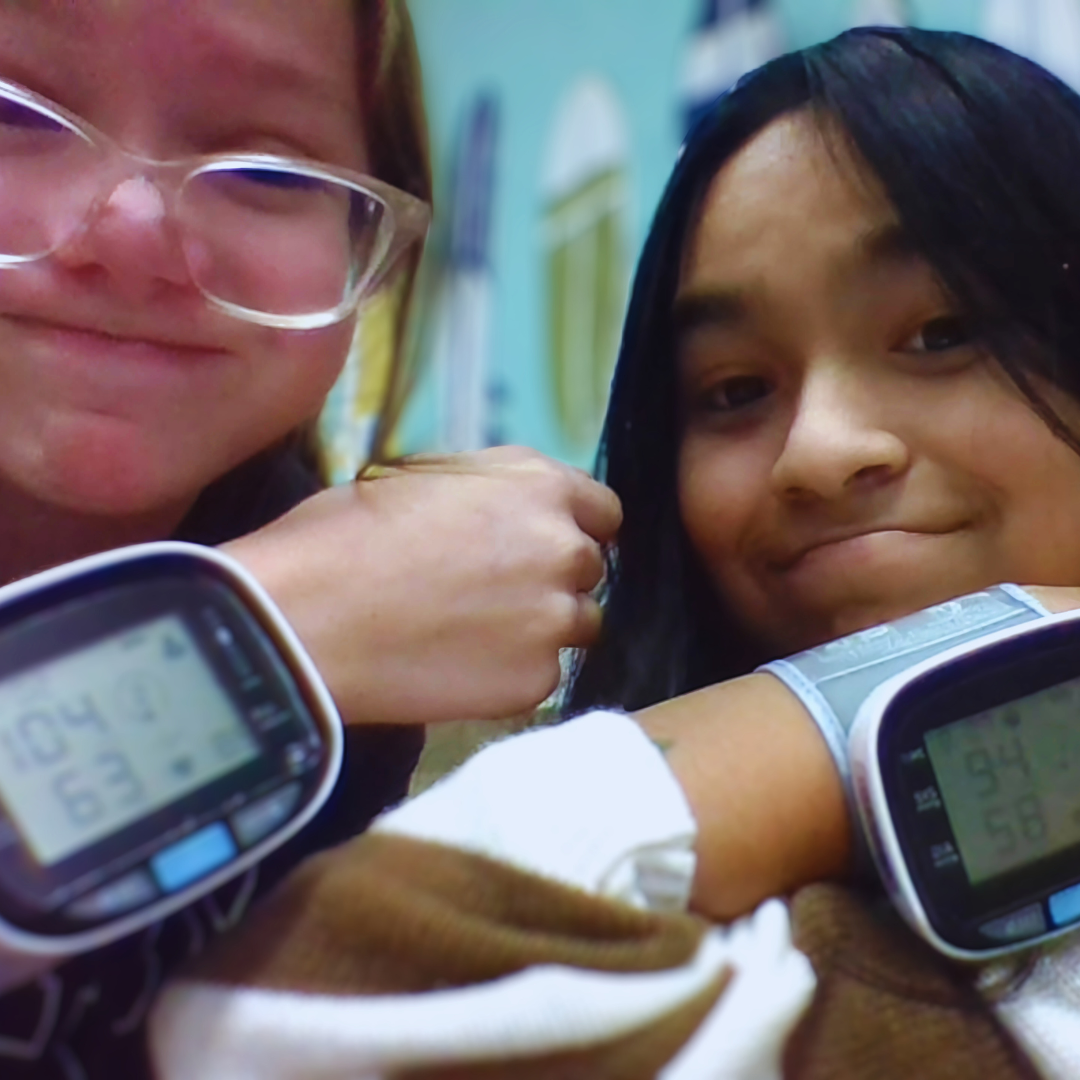 Kids use vital signs monitor from a STEM project to learn about healthcare applications.